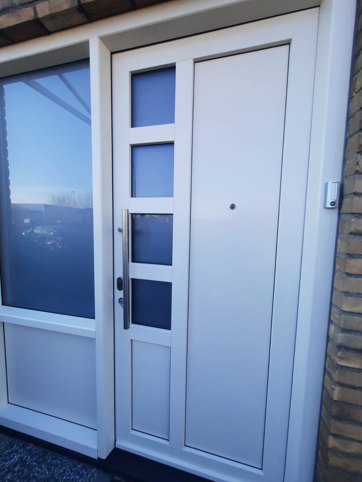 Nieuwe witte voordeur met glasstroken en zijlicht