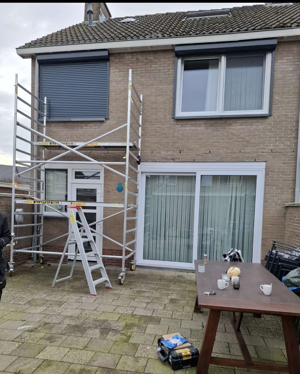 Achtergevel tijdens de montage: nieuwe schuifpui, raam en rolluik, met steiger
