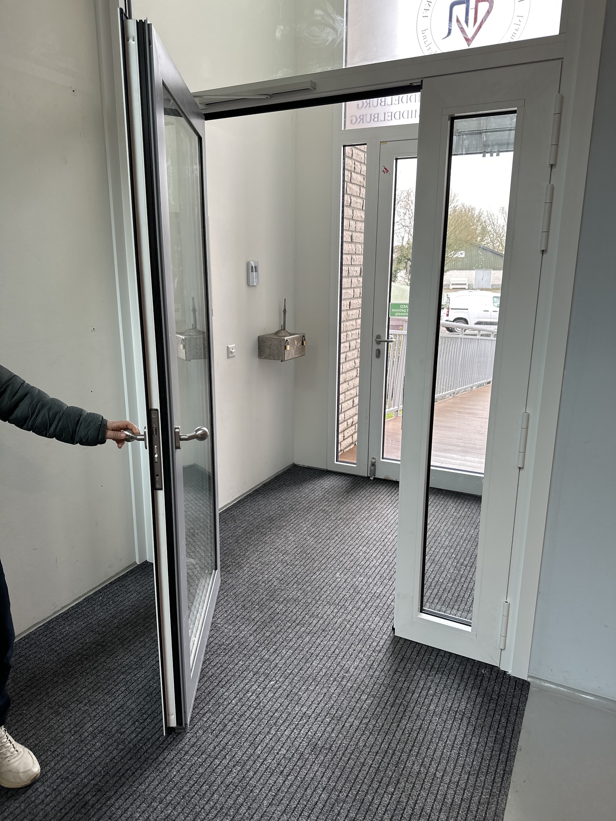 Nieuwe witte dubbele entreedeuren van een bedrijfspand